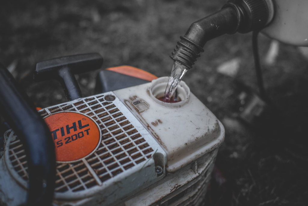 Close-up of a chainsaw being refilled