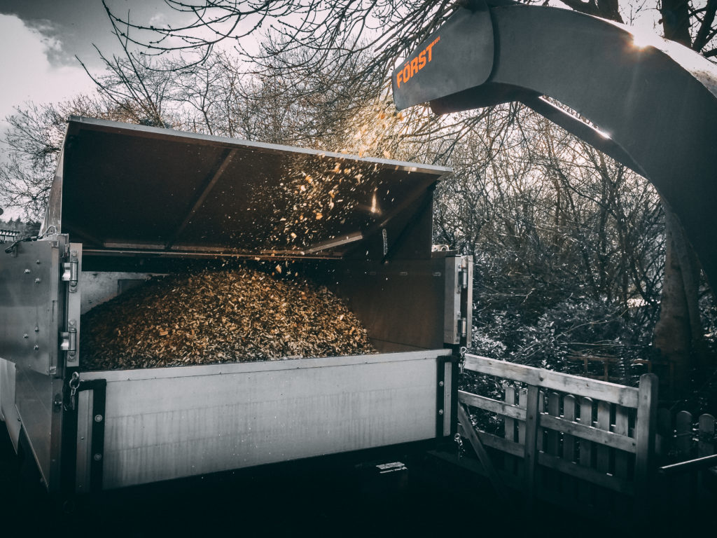 Photo of wood chipper blowing chippings into a hopper on a van